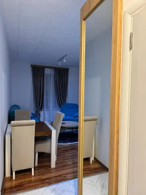 a dining room with a table and blue chairs at VEMA 4 Apartments in Belgrade