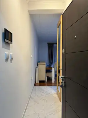 a hallway with a door and a room with a table at VEMA 4 Apartments in Belgrade