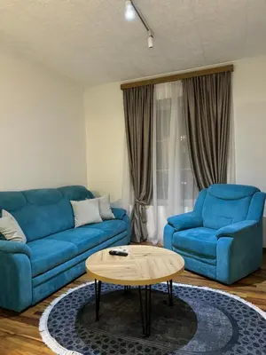 a living room with two blue couches and a coffee table at VEMA 4 Apartments in Belgrade