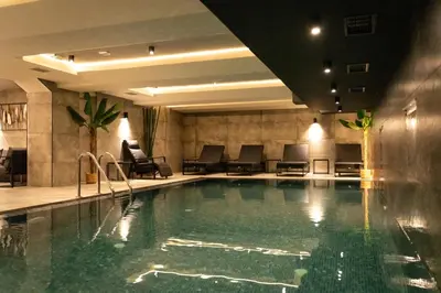 a swimming pool in a hotel room with chairs at Lumière Hotel Pool & SPA in Belgrade