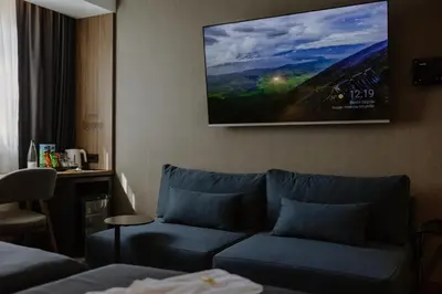 a living room with a couch and a tv on the wall at Lumière Hotel Pool & SPA in Belgrade