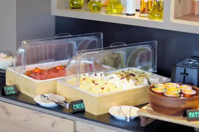 a buffet with two trays of food on a table at Lumière Hotel Pool & SPA in Belgrade