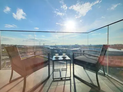 a glass balcony with two chairs and a table on it at Panoramic View Lux Apartment BW in Sajmište