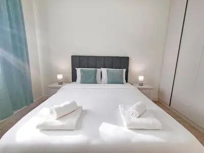 a bedroom with a large white bed with two white towels at Panoramic View Lux Apartment BW in Sajmište