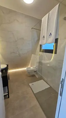 a bathroom with a toilet and a window with towels at Nikis House Beograd in Ba°evac