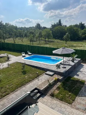 an overhead view of a swimming pool with an umbrella at Nikis House Beograd in Ba°evac