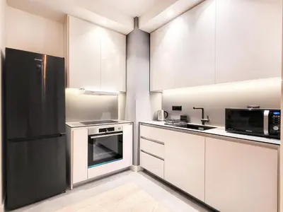 a kitchen with white cabinets and a black refrigerator at Belgrade Waterfront PROMO PRICE in Belgrade