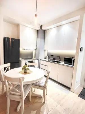 a kitchen and dining room with a white table and chairs at Belgrade Waterfront PROMO PRICE in Belgrade