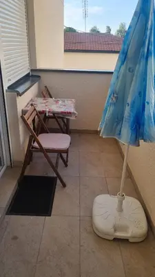 an umbrella and a chair and a table on a balcony at Apartman Lola in Novi Grad