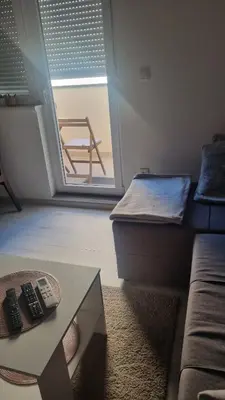 a room with a couch and a table with remote controls at Apartman Lola in Novi Grad