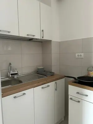 a kitchen with white cabinets and a sink at Apartman Lola in Novi Grad