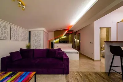 a living room with a purple couch and a bed at Boom Spa 1 Belgrade Apartments in Fontana