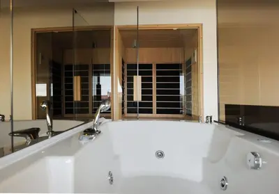 a bath tub with two faucets in a bathroom at Boom Spa 1 Belgrade Apartments in Fontana