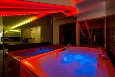 a bathroom with a large tub with red lighting at Boom Spa 1 Belgrade Apartments in Fontana