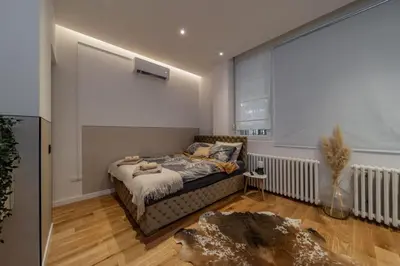 a bedroom with a bed and a large window at Rodman Belgrade Apartment in Novi Beograd