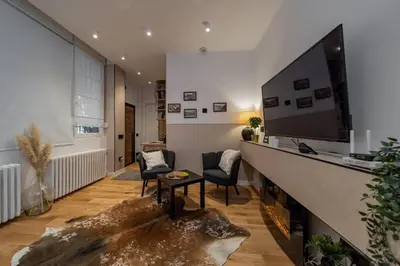 a living room with a tv and a table and chairs at Rodman Belgrade Apartment in Novi Beograd