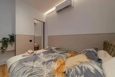 a bedroom with a bed with a comforter on it at Rodman Belgrade Apartment in Novi Beograd