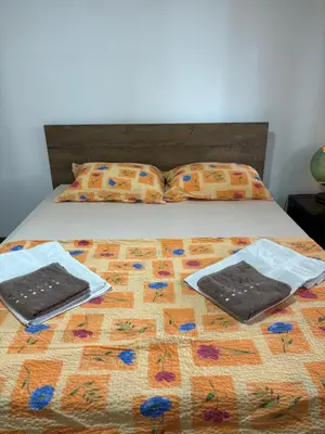 a bed with two towels and pillows on it at Kućica u pesku in Novi Vladimirovac