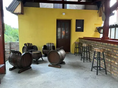 a yellow building with a bunch of chairs and tables at Kućica u pesku in Novi Vladimirovac