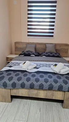 a bedroom with a bed with two towels on it at Apartments Green Beograd in Borča