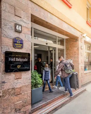 a group of people walking into a store with their luggage at Feel Belgrade Apartments in Belgrade