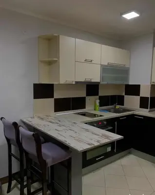 a kitchen with white cabinets and a marble counter top at Stan na dan in Voždovac