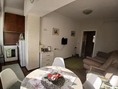 a kitchen and living room with a table and chairs at Nada Sweet House in Belgrade