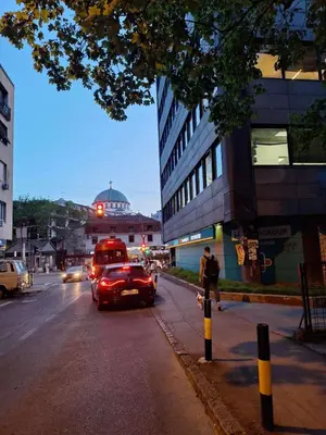 a red bus driving down a city street with cars at Nada Sweet House in Belgrade