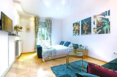 a living room with a bed and a table at Cozy apartment near Saint Sava Temple in Belgrade