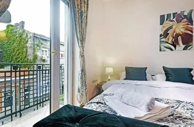 two beds in a room with a balcony at Cozy apartment near Saint Sava Temple in Belgrade