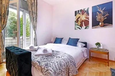 a bedroom with a bed and a large window at Cozy apartment near Saint Sava Temple in Belgrade