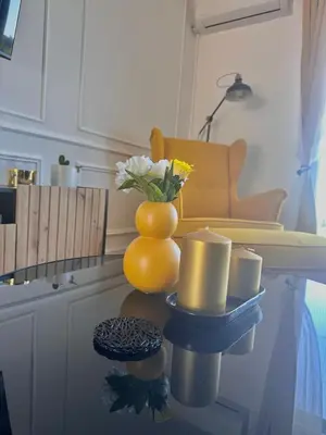 a yellow vase with flowers and candles on a table at Vila Vista Verde in Zaklopača