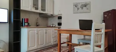 a kitchen with white cabinets and a wooden table at Zemun Riverside in Zemun