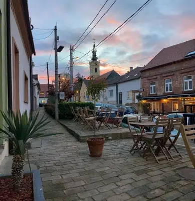 a patio with tables and chairs and a clock tower at Zemun Riverside in Zemun