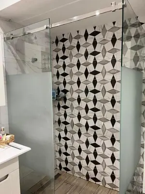 a bathroom with a shower with a tile wall at Classy and cozy near Tasmajdan park and Flower Piazza in Belgrade