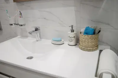 a bathroom sink with toothbrushes and towels on it at Classy and cozy near Tasmajdan park and Flower Piazza in Belgrade