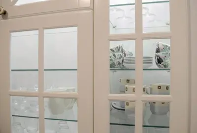 a cabinet filled with plates and cups and dishes at Classy and cozy near Tasmajdan park and Flower Piazza in Belgrade