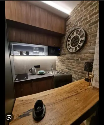 a kitchen with a wooden table and a clock on the wall at Apartment Despot in Belgrade