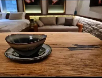 a wooden table with a black bowl on a plate on it at Apartment Despot in Belgrade