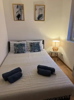 a bedroom with a large bed with two pillows on it at Caravaggio Apartman in Mladenovac