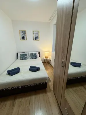a bedroom with two beds and a sliding glass door at Caravaggio Apartman in Mladenovac