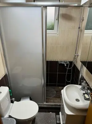 a bathroom with a shower and a toilet and a sink at Caravaggio Apartman in Mladenovac