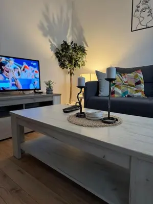 a living room with a coffee table and a tv at Caravaggio Apartman in Mladenovac
