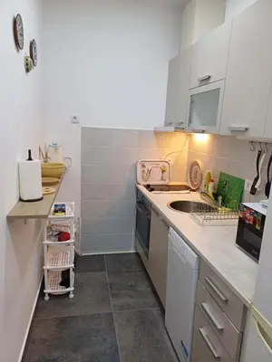 a small kitchen with white cabinets and a sink at Amazing apartment in Zemun