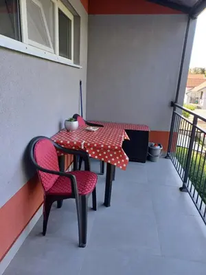 a red and white table and chairs on a balcony at Amazing apartment in Zemun