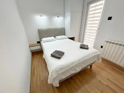 a bedroom with a white bed with two towels on it at Central Elegance in Belgrade