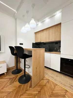 a kitchen with a counter with two chairs and a table at Central Elegance in Belgrade