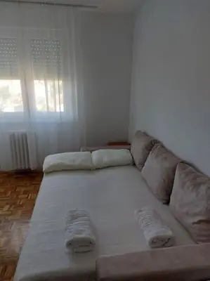 a large couch in a living room with a window at Toni apartments in Voždovac