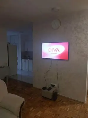 a television hanging on a wall in a living room at Toni apartments in Voždovac