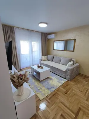 a living room with a couch and a tv at Golden dream apartman in Pančevo